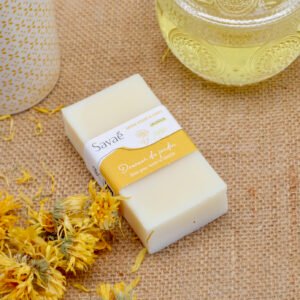 savon-surgras-calendula-peaux-sensibles savon à froid surgras au calendula sur set de table avec fleurs de souci séchées et huile de tournesol oléique