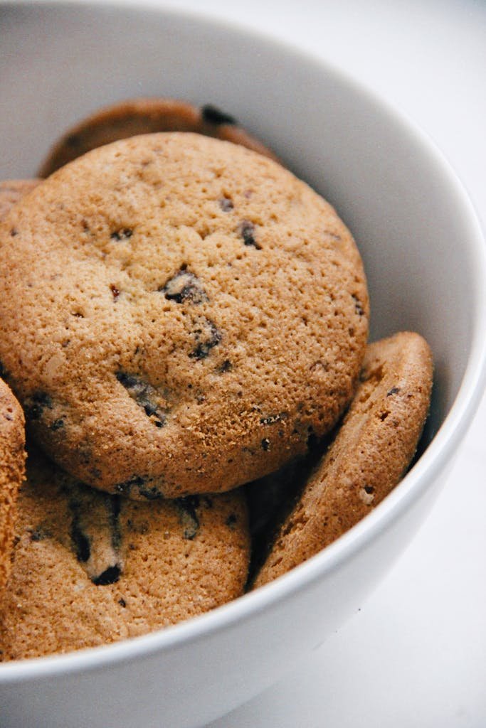 Fête des grands-mères : fête commerciale ou vrai moment de partage ? 3 A close-up of freshly baked chocolate chip cookies in a white bowl, perfect for food blogs.